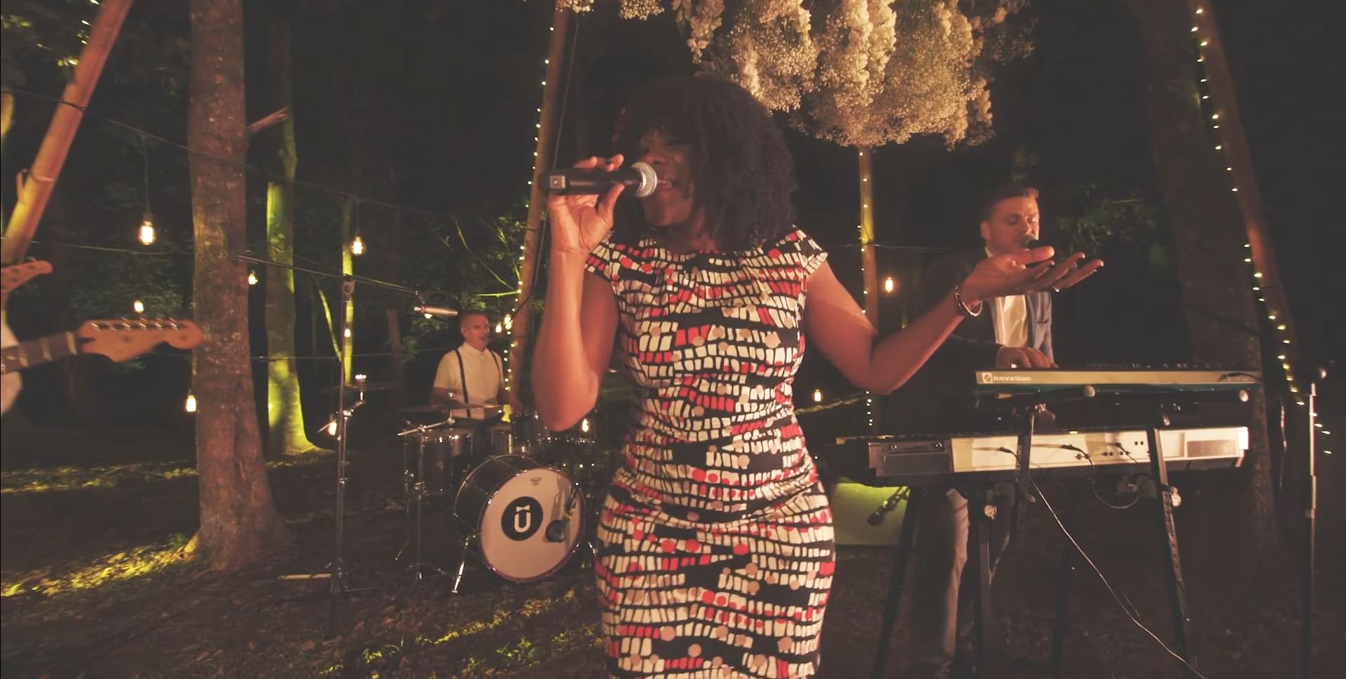 Female singer performing on stage with band members behind her